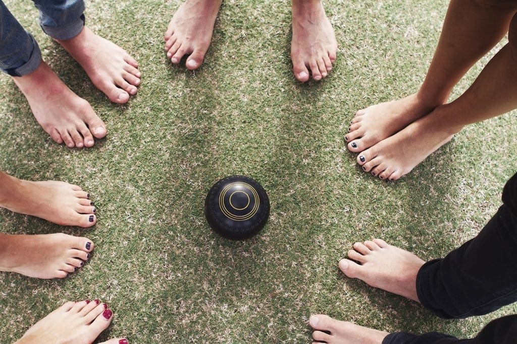 Overhead view of bare feet friends around lawn bowls Barefoot bowls - Sunshine Coast - Maroochydore